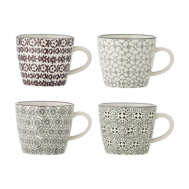 Karine Mug in four assorted stoneware designs with handles, each handstamped in a different pattern—small flowers, scrolling lattice, rosette circles, or tiled motif—on a plain white background.