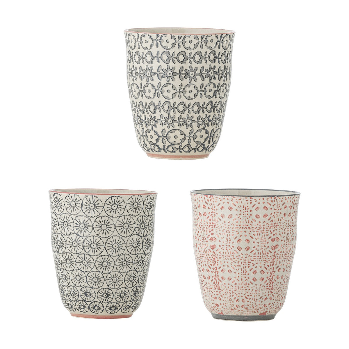 Cécile Cup 300ml, three handleless ceramic cups with floral decal patterns in grey and coral tones on cream, shown together on a plain white background.
