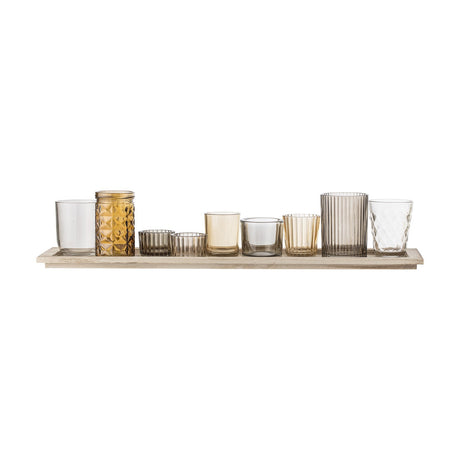 Sanga Glass Tealight Holders Set of 10 on a long paulownia wood tray, featuring nine mismatched brown glass votives in plain, ribbed, faceted and diamond patterns, shown on a white background.