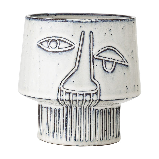 Sacad stoneware plant pot in white, featuring a raised-line face design with one open eye, one closed eye, a long nose, and ribbed footed base, shown on a plain background.