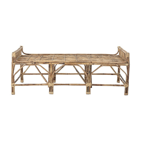 Pammi Cane Bench in natural bamboo and rattan, long low design with slatted seat, raised side rails, and exposed cane legs, shown on a plain white background.