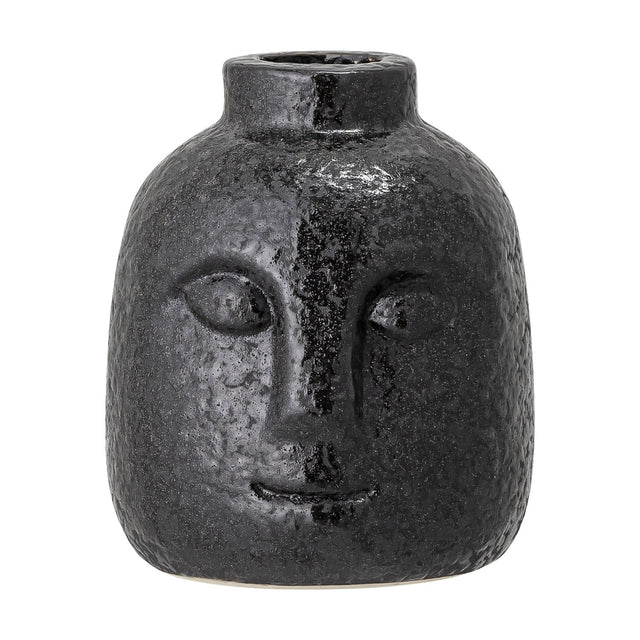 Eliot Stoneware Candle Holder in black, a small face-shaped taper holder with relief eyes, nose and smile, textured glossy finish, on a plain white background.