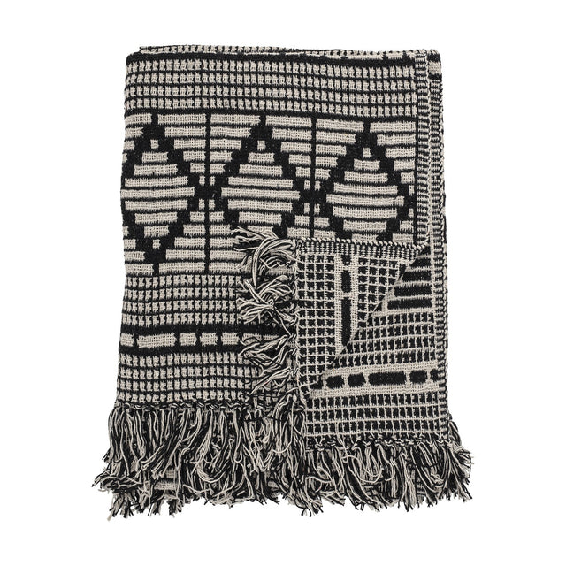 Gutte Geometric Throw in black and cream, woven with diamond and checked patterns, finished with thick fringe edges, folded against a plain white background.