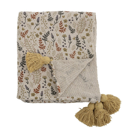 Filipa Floral Cotton Throw in Multi, folded square showing an off-white base with rust, olive and navy floral fern pattern and chunky mustard corner tassels, on a plain white background.