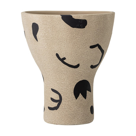 Nans Terracotta Vase 27cm in Natural, a footed cup-shaped vase with flared bowl, slim stem and broad base, grainy terracotta finish with bold black painted shapes, curls and dots.