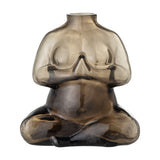 Elze Glass Vase 12.5cm in Brown, shaped as a seated figure with crossed legs and hands pressed together, translucent glass darkest at the base, on a plain white background.