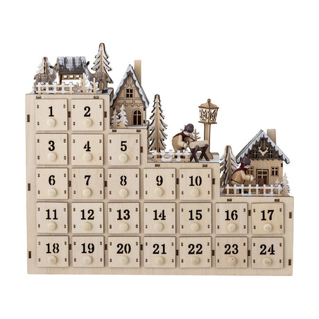 Richie Wooden Advent Calendar with Light in natural plywood, featuring 24 numbered drawers with round knobs beneath a tiered miniature winter village with houses, fir trees, and figures.