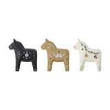 Set of three Siffer resin horse tealight holders in black, tan, and white, each painted with folk-art Christmas motifs like snowflakes, birds, and stars, shown on a plain white background.