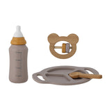 Riina Baby Play Set of 4 in grey, showing a toy bottle with printed scale, a wooden bear-shaped rattle, a divided grey plate, and a wooden spoon on a white background.