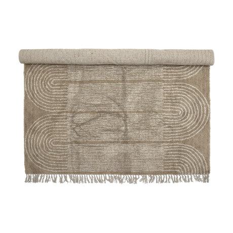 Zeynep Cotton Rug 215x150cm in brown, partially rolled, showing a tufted arch pattern with fringed edges on a plain white background.