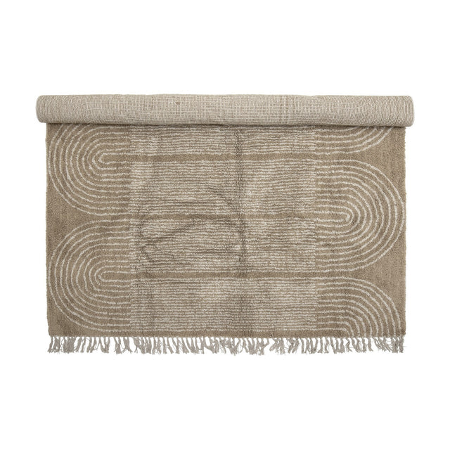 Zeynep Cotton Rug 215x150cm in brown, partially rolled, showing a tufted arch pattern with fringed edges on a plain white background.