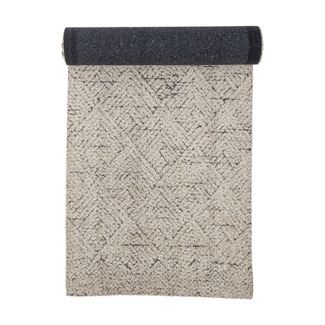 Saxo Cotton Rug 245x75cm runner, natural tone with geometric diamond pattern, shown half-rolled to reveal a dark woven underside, on a white background.