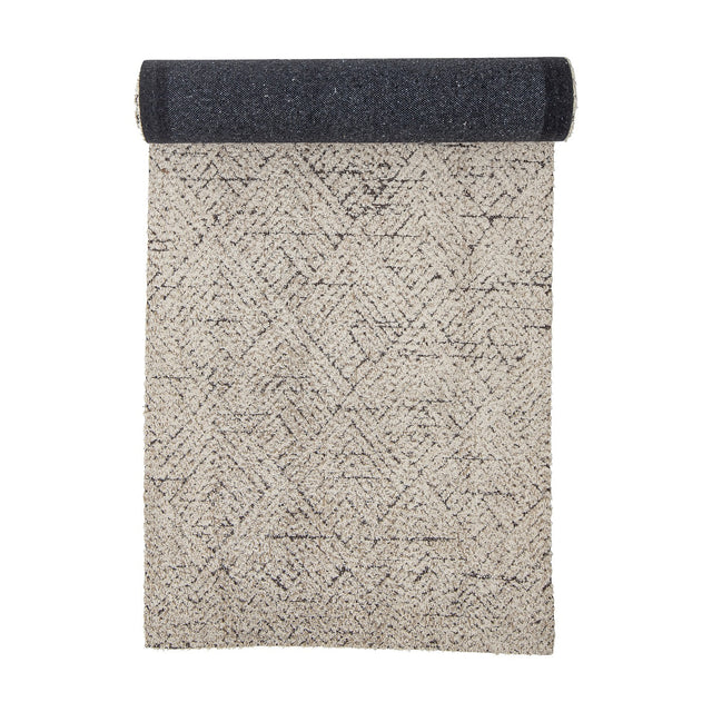Saxo Cotton Rug 245x75cm runner, natural tone with geometric diamond pattern, shown half-rolled to reveal a dark woven underside, on a white background.