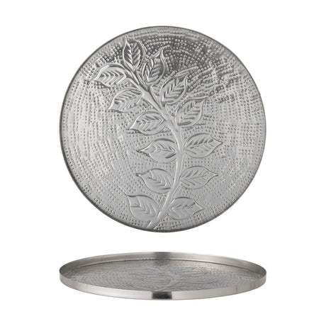 Round silver metal tray with a low rim, featuring a raised leafy branch design on a dotted textured background, shown front-facing and side-on.