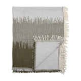 Lucienne Throw in Green, a folded woven acrylic-blend throw with a grass-like fade from deep green to light grey and knotted cream fringing, shown on a white background.