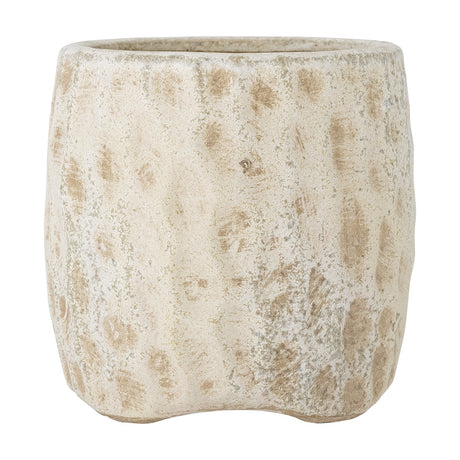 Mawni Terracotta Plant Pot in Natural, a round planter with a dimpled, mottled weathered finish and small feet, shown on a plain white background.