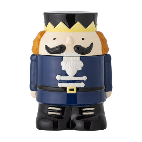 Feast Nutcracker Christmas storage jar, 900ml ceramic jar shaped as a soldier with crown, moustache, navy coat and black boots, lid as head and hat, on a white background.