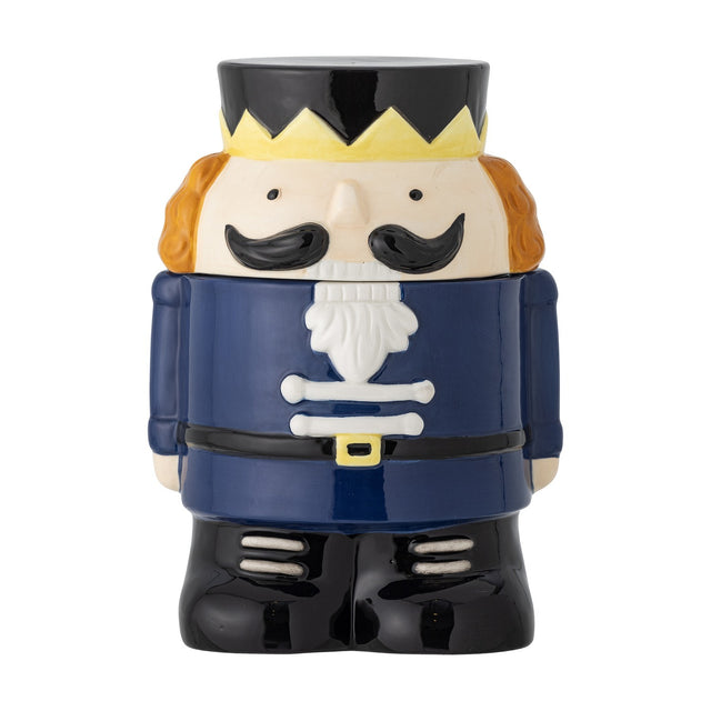 Feast Nutcracker Christmas storage jar, 900ml ceramic jar shaped as a soldier with crown, moustache, navy coat and black boots, lid as head and hat, on a white background.