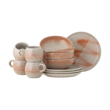 Paula Stoneware Breakfast Set of 12 in orange reactive glaze, showing four round-bellied cups with loop handles, four bowls and four side plates, on a plain white background.