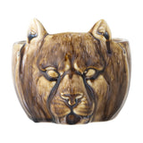 Abner Stoneware Plant Pot in Brown, a small ceramic planter moulded as a big cat's face with pointed ears and relief eyes under a glossy brown glaze, on a white background.