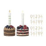 Set of 2 resin birthday cake figurines with berry toppings, striped and dotted candles with gold flames, plus two gold number picks 0-9, on white background.