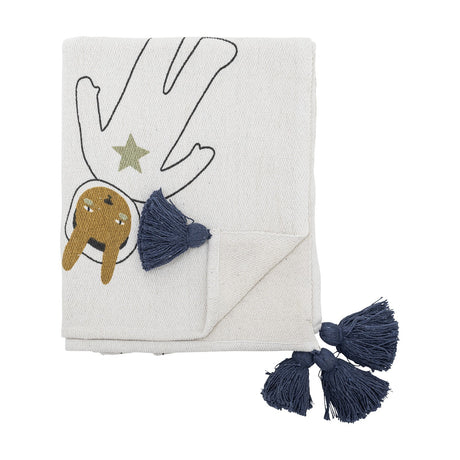 Space Cotton Throw in cream, folded, showing a printed astronaut figure with star and outlined arms, finished with navy tassel corners, on a plain white background.
