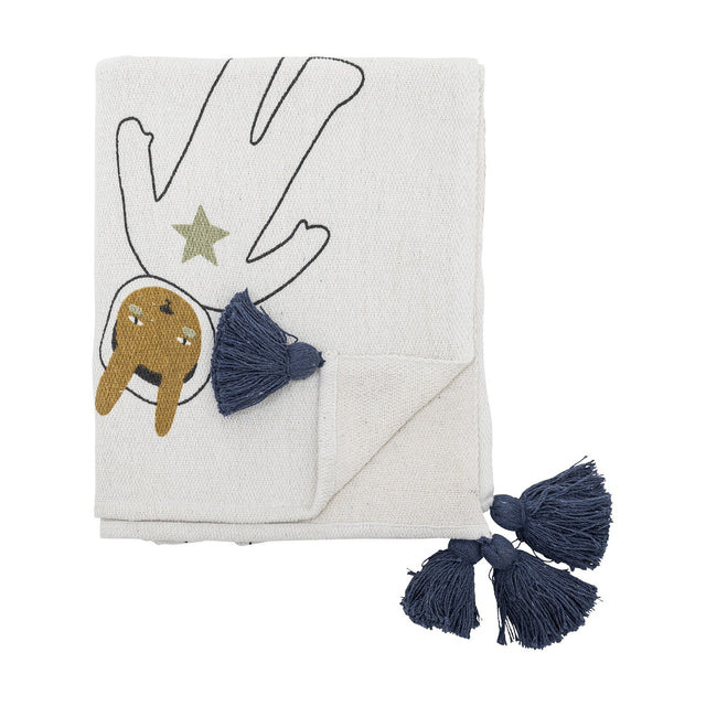 Space Cotton Throw in cream, folded, showing a printed astronaut figure with star and outlined arms, finished with navy tassel corners, on a plain white background.