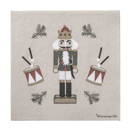 Jolly Paper Christmas Napkin in beige, pack of 20, featuring a crowned nutcracker soldier with drums and pine sprigs on a plain background.