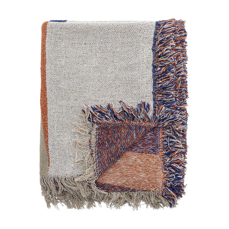 Clarita Cotton Throw in multicoloured woven cotton, folded to show cream, orange and blue geometric blocks with contrasting fringed edges on a white background.