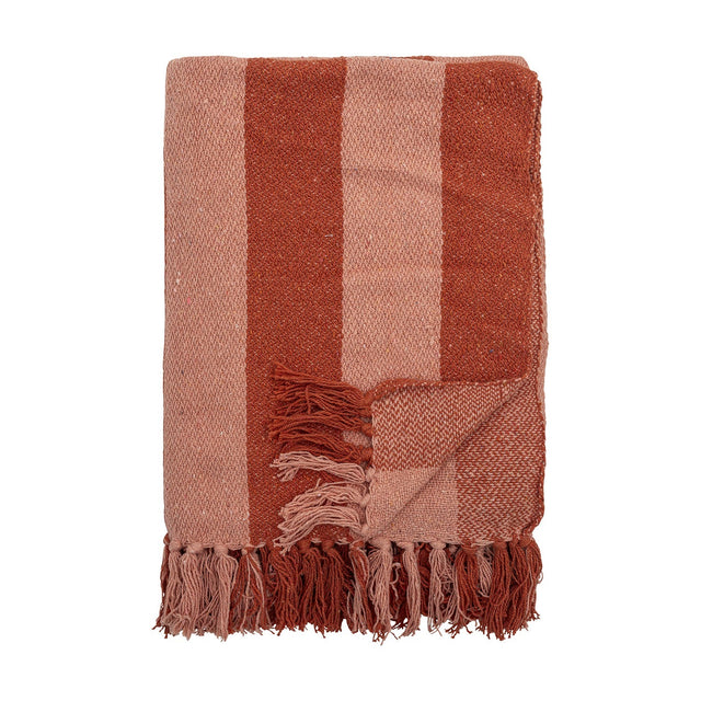 Frello Striped Cotton Throw in Orange, folded to show broad terracotta and pink stripes with knotted fringe edges, set against a plain white background.