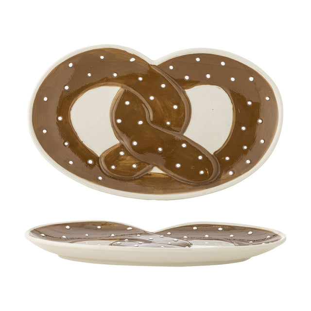 Stoneware serving platter shaped like a pretzel, glossy brown knot design with white salt-like dots on a cream base, shown from top and side views on a white background.