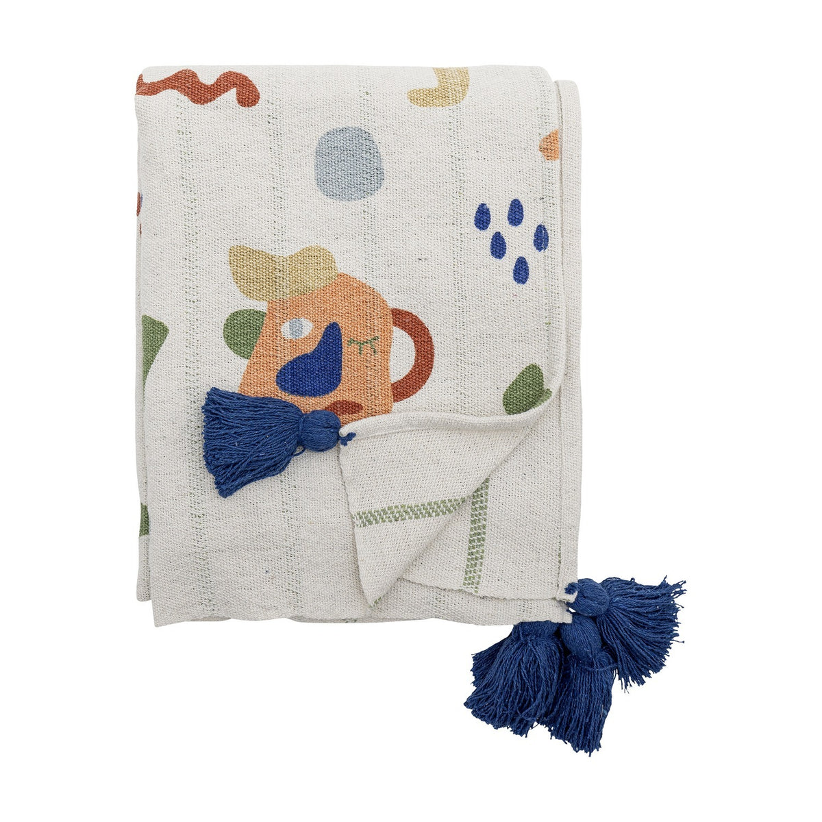 Sylvie Cotton Throw folded on a white background, cream cotton blend fabric printed with multicoloured abstract shapes and a playful jug-like face, finished with navy tassel corners.