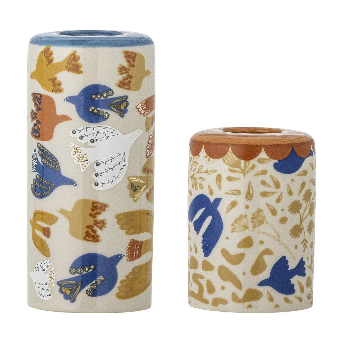 Set of 2 cylindrical stoneware candle holders with colourful bird and floral illustrations, one tall with a blue rim, one short with a rust scalloped rim, on white background.