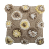 Somma Wool Cushion in Natural, a 50x50cm square cushion with shaggy tufted rosettes in beige, cream and yellow across a woven ground, shown on a white background.