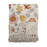 Vivielle Floral Throw in multicoloured cotton-blend fabric, folded to show an open flower, leaf and bird print with long knotted fringe, on a plain white background.