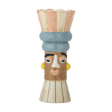 Minio Ceramic Vase 17cm in multi, a face-shaped bud vase with scalloped petal rim, blue banded headdress, painted features and striped tapered base, shown on a plain white background.
