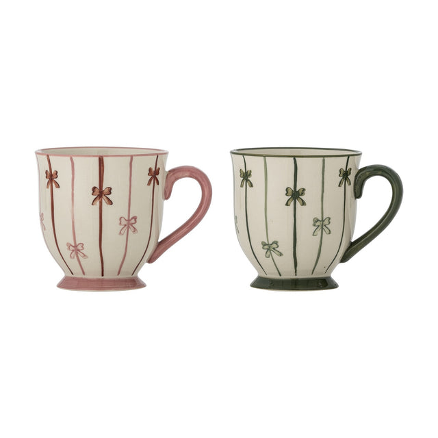 Hope Striped Stoneware Christmas Mugs, set of 2, footed stoneware mugs with curved handles in pink and green, hand-painted vertical stripes and bow motifs, on a white background.