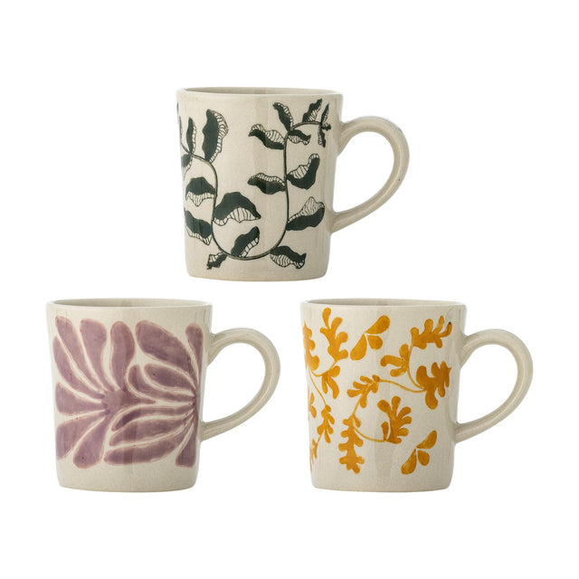 Set of three Fauni stoneware cups, 220ml, with handles, hand-painted leaf designs in green, purple and mustard on cream, shown on a white background.
