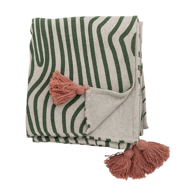 Woodsby Striped Cotton Throw folded on a white background, showing green wavy stripes on cream fabric with pink tassels at the corners and plain reverse side.