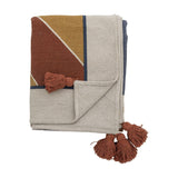 Sun Cotton Throw in multicoloured woven cotton blend, folded with rust, mustard and cream geometric pattern and rust tassels, shown on a white background.