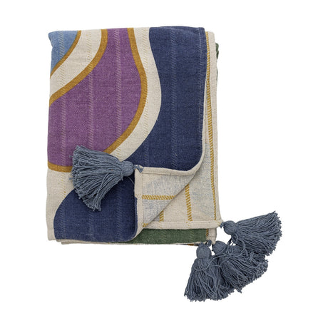 Salacia Throw in Multi, folded with curved abstract bands in purple, navy, and mustard outlines, finished with blue-grey tassels, shown on a white background.