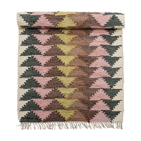 Desmond Geometric Cotton Rug, 180x80cm, with a mirrored triangle pattern in pink, mustard, brown and dark green on cream, fringed edges, shown rolled at the top on a white background.