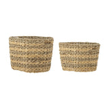 Indra Striped Water Hyacinth Baskets Set of 2 in natural, oval woven storage baskets with alternating flat and twisted seagrass bands and a rope-edged rim, shown on a white background.