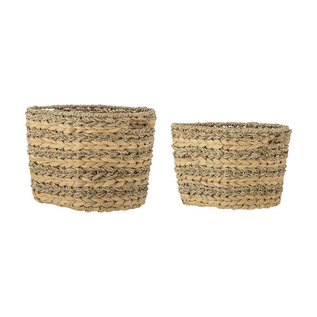 Indra Striped Water Hyacinth Baskets Set of 2 in natural, oval woven storage baskets with alternating flat and twisted seagrass bands and a rope-edged rim, shown on a white background.