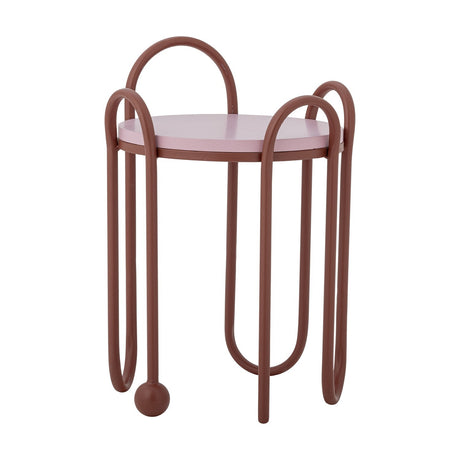 Whimsica Round Iron Side Table in red with a pink round top, featuring looped tubular legs arching above and below, one ending in a ball foot, shown on a plain white background.