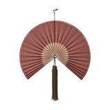 Jaime Bamboo Wall Decor in pink, a pleated fan-shaped wall art piece with a long hanging tassel at the hub, shown on a plain white background.