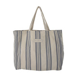 Trina Striped Cotton Shopping Bag in blue, a cotton tote with vertical stripes of varying widths, two fabric handles, and a brand label on the front, shown against a plain white background.