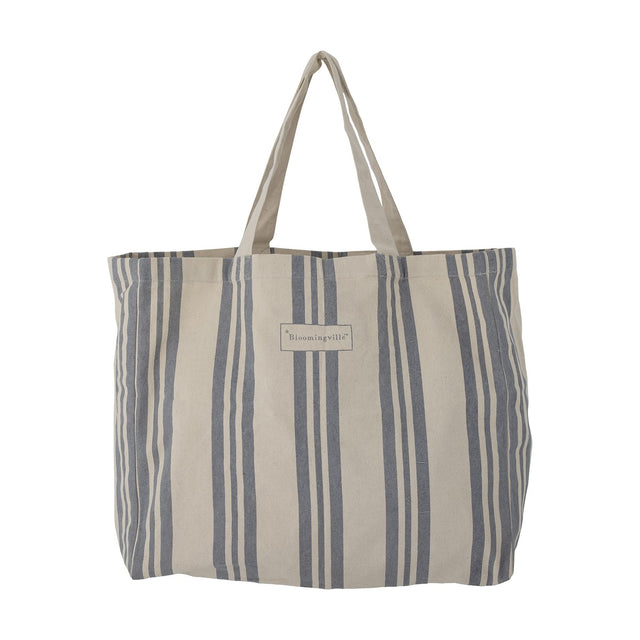 Trina Striped Cotton Shopping Bag in blue, a cotton tote with vertical stripes of varying widths, two fabric handles, and a brand label on the front, shown against a plain white background.