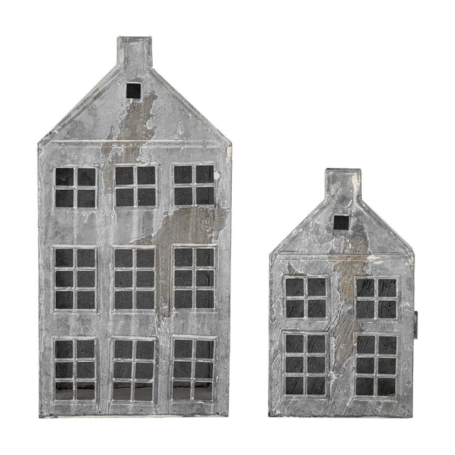 Heidrun House iron Christmas lanterns, set of 2, townhouse-shaped candle holders with pitched roofs, chimneys and paned windows in a weathered grey finish on a white background.
