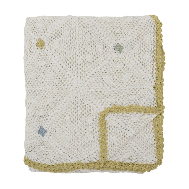 Rovigo Cotton Throw in natural white, hand-crocheted lacy motifs with scattered coloured stitches and a scalloped mustard-yellow edge, folded on a plain white background.